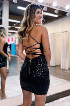 Robe de bal courte à paillettes noires, bretelles spaghetti et dos croisé, coupe fourreau scintillante.