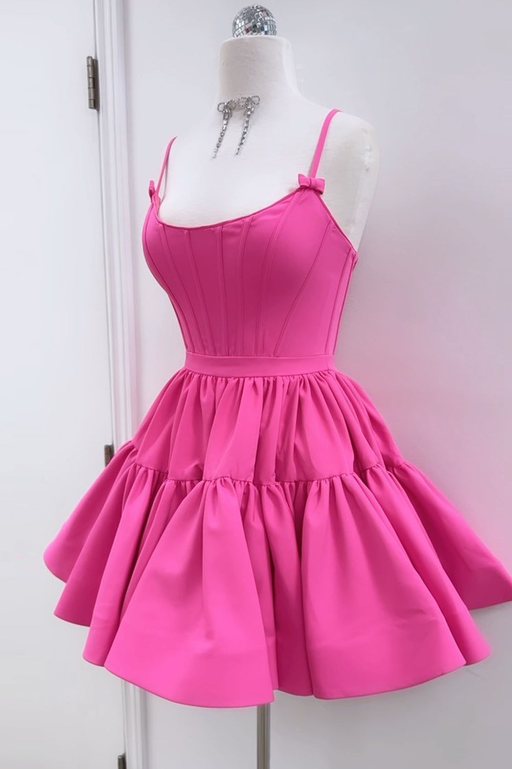 Lindo vestido corto rosa fucsia de tirantes finos con corte en A y espalda cruzada, ideal para fiestas de bienvenida.