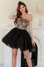 Vestido corto negro de fiesta con escote barco y detalles de pedrería.