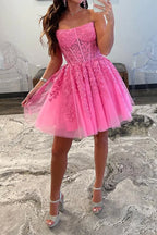 Magnifique robe de bal rose bustier sans bretelles, coupe trapèze, ornée d'appliqués