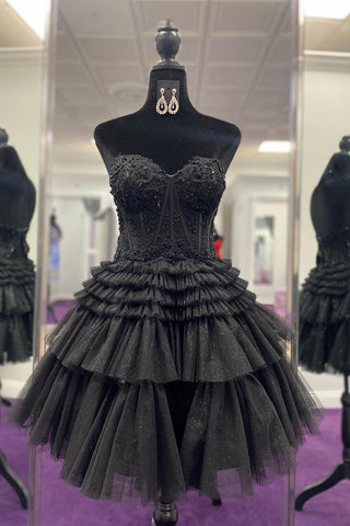 Elegante vestido negro de corte A con escote corazón y corsé, con volantes, ideal para fiestas de bienvenida.