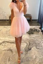 Vestido corto rosa claro de fiesta con escote en V profundo y corte en A, con plumas.