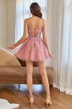 Robe de bal courte rose poudré à col V et coupe trapèze, ornée d'appliqués