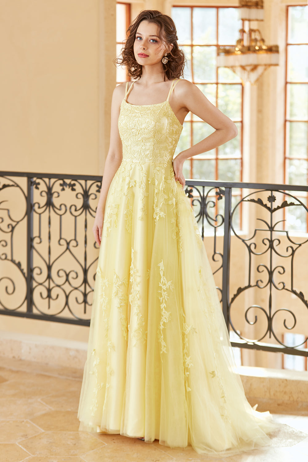 Magnifique robe de bal longue jaune à bretelles spaghetti et coupe trapèze, ornée d'appliqués.