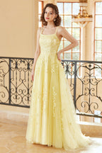 Magnifique robe de bal longue jaune à bretelles spaghetti et coupe trapèze, ornée d'appliqués.