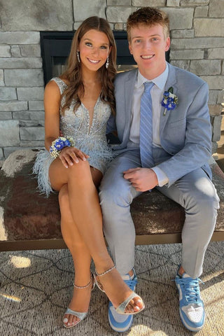 Vestido corto plateado de fiesta con escote en V profundo y detalles de plumas.