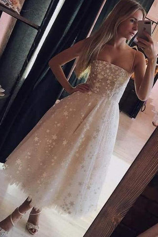Vestido de fiesta rosa perla con tirantes finos, corte en A y largo hasta la rodilla, con cuentas.