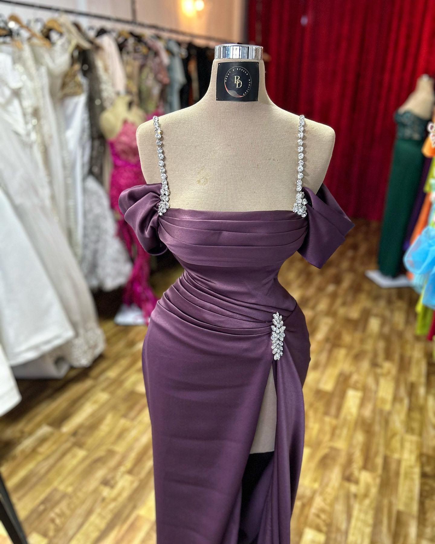 Impresionante vestido de fiesta sin mangas con tirantes finos, pedrería y abertura frontal, de satén.