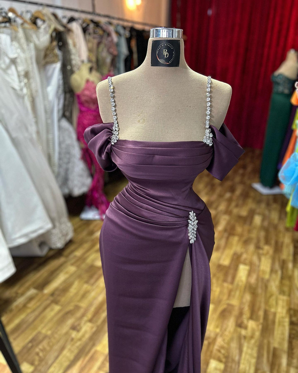 Impresionante vestido de fiesta sin mangas con tirantes finos, pedrería y abertura frontal, de satén.