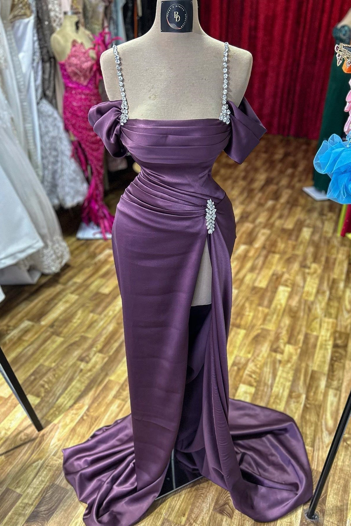 Impresionante vestido de fiesta sin mangas con tirantes finos, pedrería y abertura frontal, de satén.
