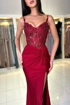 Impresionante vestido largo de sirena color burdeos con tirantes finos, encaje y abertura.