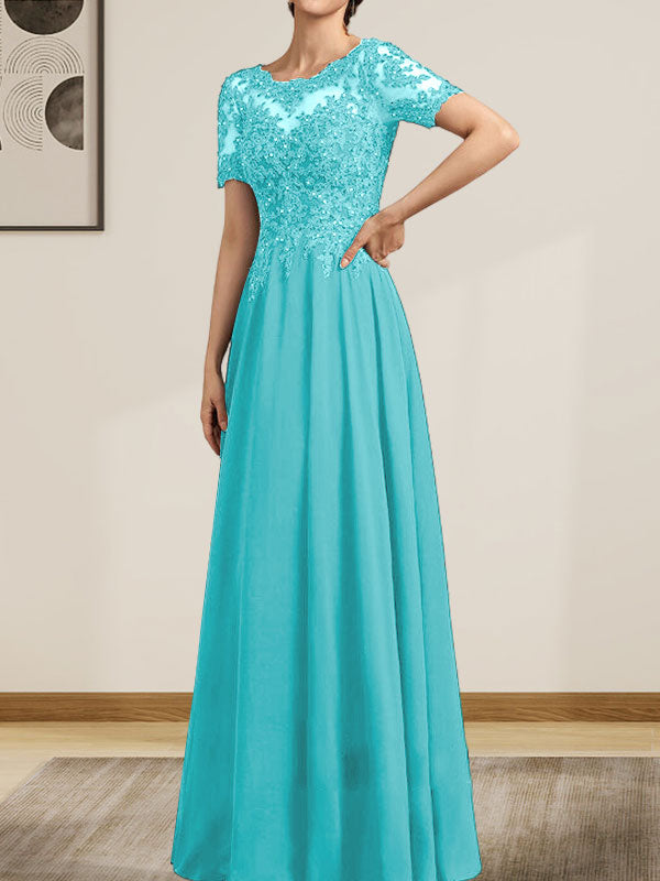 Robe de mariée longue en mousseline de soie et dentelle, coupe trapèze, décolleté illusion, ornée de sequins et de perles.