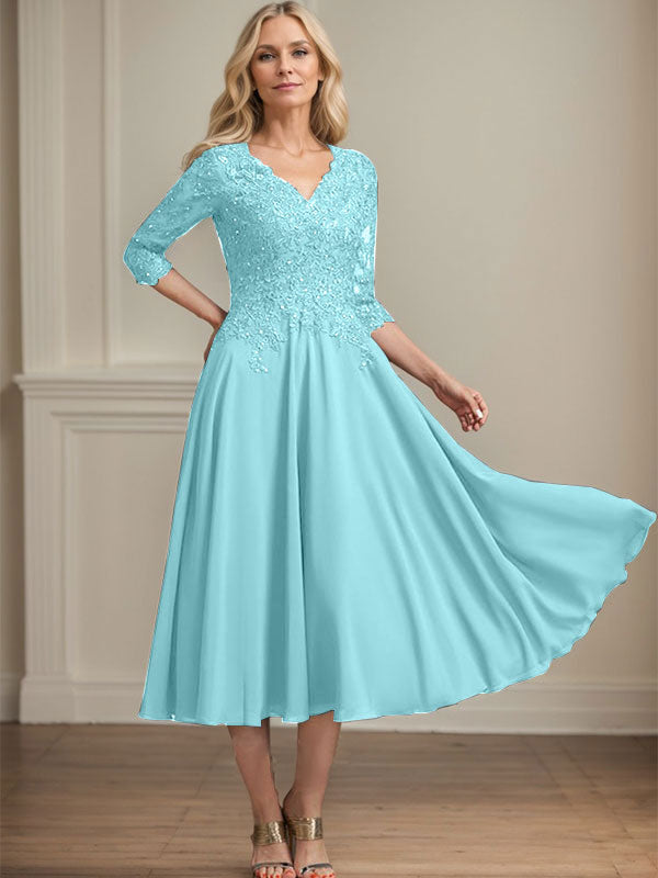 Vestido de corte A, escote en V, largo hasta la rodilla, de gasa, encaje, con lentejuelas y pedrería para la madre de la novia. 