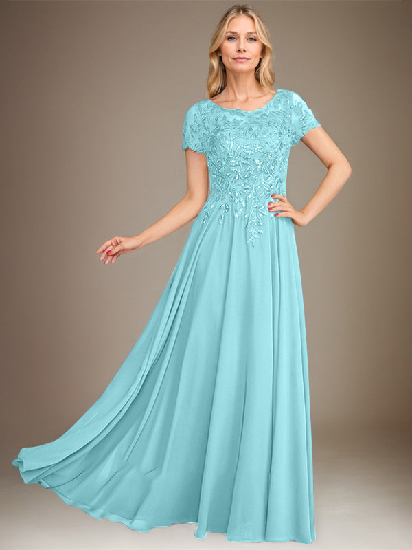 Robe de mariée longue en mousseline de soie, coupe trapèze, décolleté rond, ornée d'appliqués et de sequins, idéale pour la mère de la mariée. 