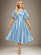 Vestido de novia de satén elástico, corte en A, escote en V, largo hasta la rodilla, con cuentas y pliegues. 