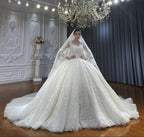 Vestido de novia de corte princesa, escote corazón, tul, mangas largas, apliques y encaje hasta el suelo.
