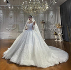 Vestido de novia de corte princesa, escote corazón, tul, mangas largas, apliques y encaje hasta el suelo.