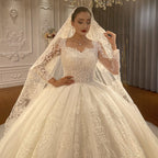 Vestido de novia de corte princesa, escote corazón, tul, mangas largas, apliques y encaje hasta el suelo.