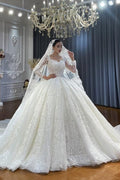 Vestido de novia de corte princesa, escote corazón, tul, mangas largas, apliques y encaje hasta el suelo.