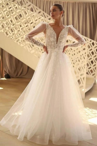 Precioso vestido de novia largo de corte A, escote en V, encaje y tul con mangas largas.