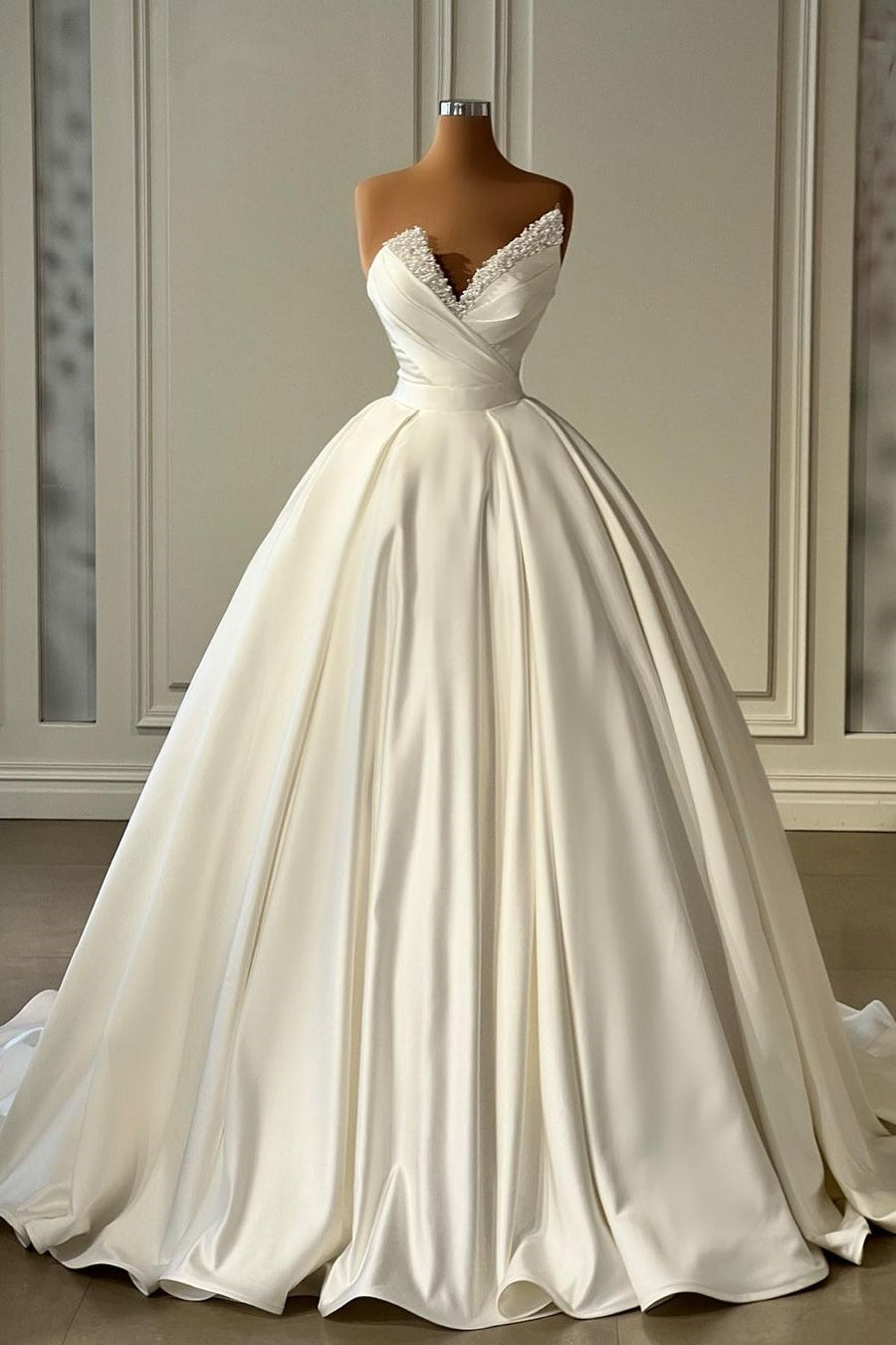 Magnifique robe de mariée princesse longue en satin ivoire, coupe trapèze, ornée de perles