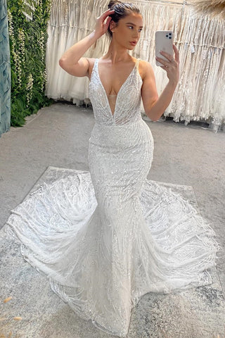 Precioso vestido de novia largo de sirena con escote en V, sin mangas, espalda descubierta y detalles de encaje, adornado con cuentas.