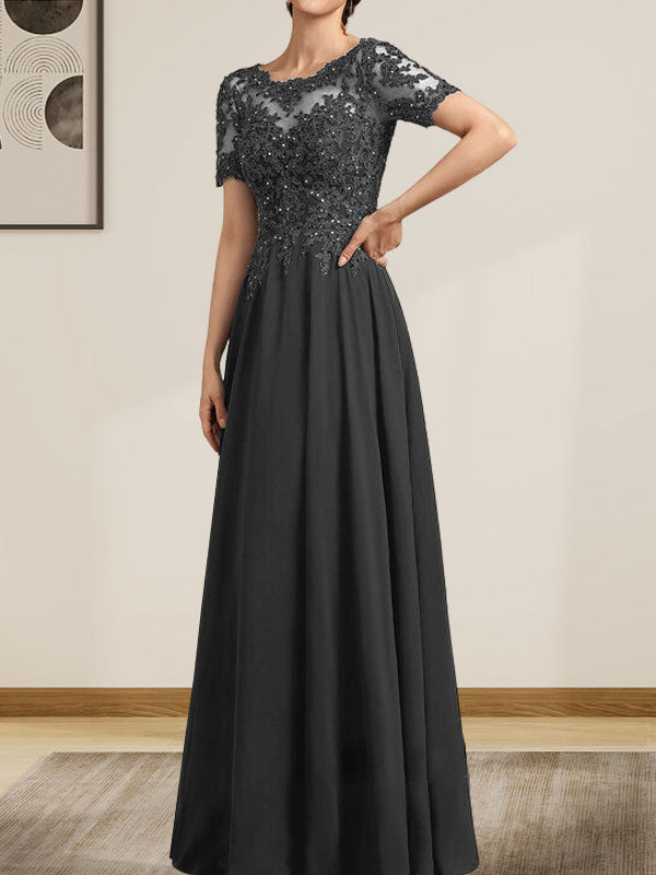 Robe de mariée longue en mousseline de soie et dentelle, coupe trapèze, décolleté illusion, ornée de sequins et de perles.
