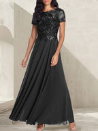 Vestido largo de corte A, color gris carbón, con escote redondo y detalles de pedrería, ideal para la madre de la novia.