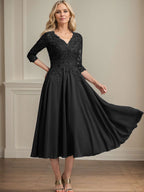Vestido de corte A, escote en V, largo hasta la rodilla, de gasa, encaje, con lentejuelas y pedrería para la madre de la novia. 