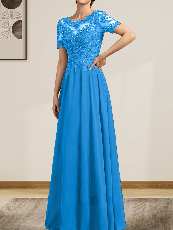 Robe de mariée longue en mousseline de soie et dentelle, coupe trapèze, décolleté illusion, ornée de sequins et de perles.