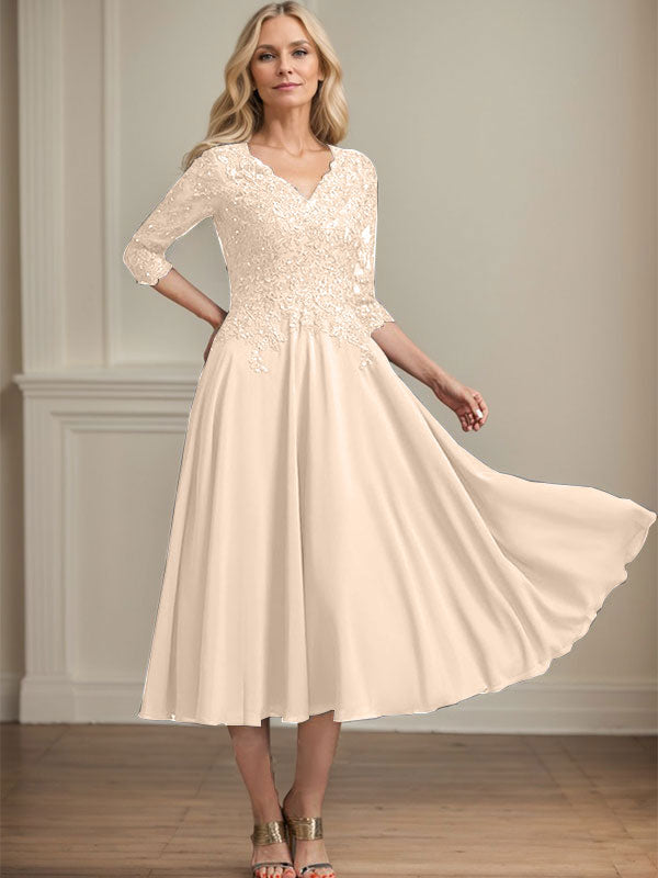 Vestido de corte A, escote en V, largo hasta la rodilla, de gasa, encaje, con lentejuelas y pedrería para la madre de la novia. 
