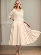 Vestido de corte A, escote en V, largo hasta la rodilla, de gasa, encaje, con lentejuelas y pedrería para la madre de la novia. 