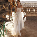Robes de mariée bohèmes en dentelle, tulle et pompons, style plage, décolleté cœur, épaules dénudées, coupe trapèze, dos nu illusion, laçage, collection 2023