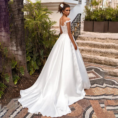 Vestido de novia bohemio con mangas cortas, cuello ilusión y apliques de satén. Vestido de novia estilo princesa playera. Vestidos de novia de tallas grandes, confeccionados a medida.