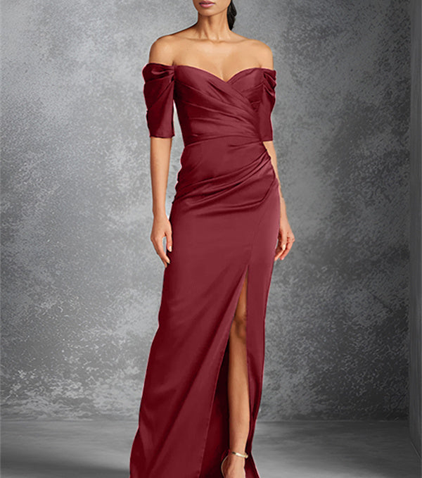 Vestido de novia de corte recto/columna, con hombros descubiertos, manga corta y largo hasta el suelo, con abertura frontal. 