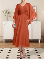 Vestido de corte A, escote en V, largo hasta la rodilla, de gasa, encaje, con lentejuelas y pedrería para la madre de la novia.