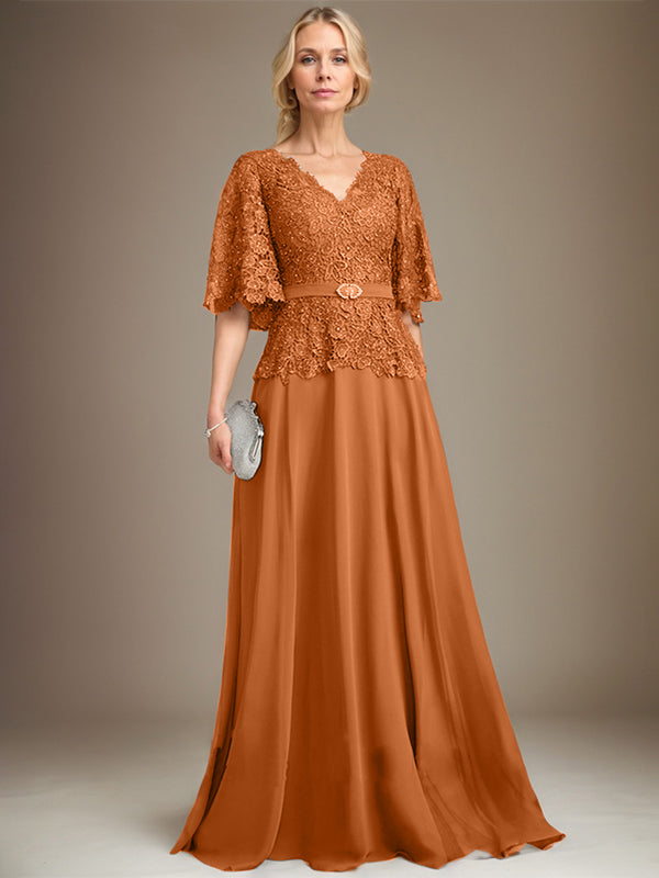 Vestido de novia de corte A, escote en V, largo hasta el suelo, de gasa y encaje, con broche de cristal y pedrería. 