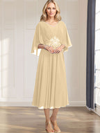 Robe de mariée trapèze en mousseline de soie, longueur thé, col en V, ornée de sequins plissés, d'appliques de dentelle et de perles. 