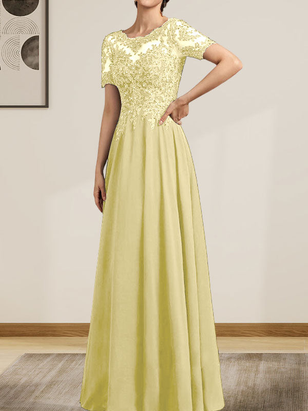 Robe de mariée longue en mousseline de soie et dentelle, coupe trapèze, décolleté illusion, ornée de sequins et de perles.