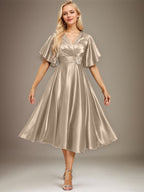Vestido de novia de satén elástico, corte en A, escote en V, largo hasta la rodilla, con cuentas y pliegues. 