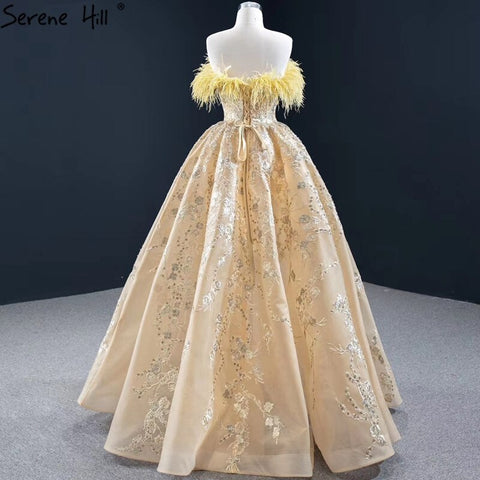 Vestido de noche sexy sin tirantes corte A color champán, con hombros descubiertos, plumas y brillo, modelo HM67164 