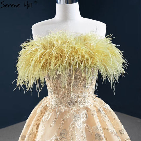 Vestido de noche sexy sin tirantes corte A color champán, con hombros descubiertos, plumas y brillo, modelo HM67164 