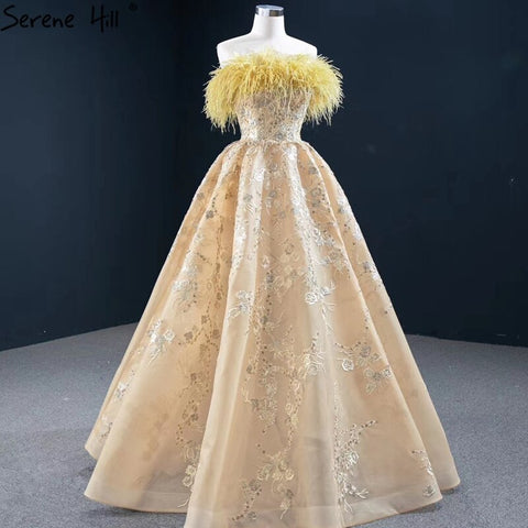 Vestido de noche sexy sin tirantes corte A color champán, con hombros descubiertos, plumas y brillo, modelo HM67164 