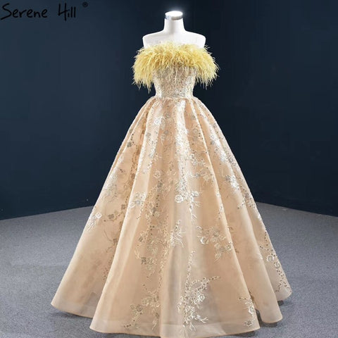 Vestido de noche sexy sin tirantes corte A color champán, con hombros descubiertos, plumas y brillo, modelo HM67164 