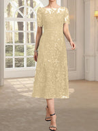 Vestido de novia de encaje con lentejuelas, corte en A, escote redondo ilusión y largo hasta la rodilla.