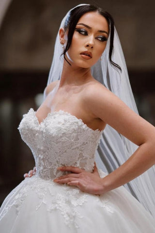 Vestidos de novia de corte princesa, sin mangas, con escote corazón y encaje hasta el suelo, adornados con apliques.