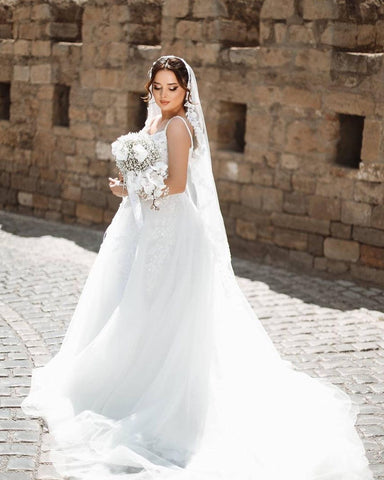 Robe de mariée blanche longue chic, coupe trapèze, bretelles spaghetti, dentelle sans manches