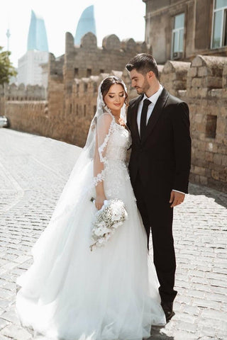 Robe de mariée blanche longue chic, coupe trapèze, bretelles spaghetti, dentelle sans manches