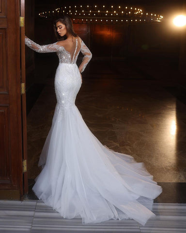 Elegante vestido de novia largo blanco de sirena con encaje, pedrería y mangas largas de tul
