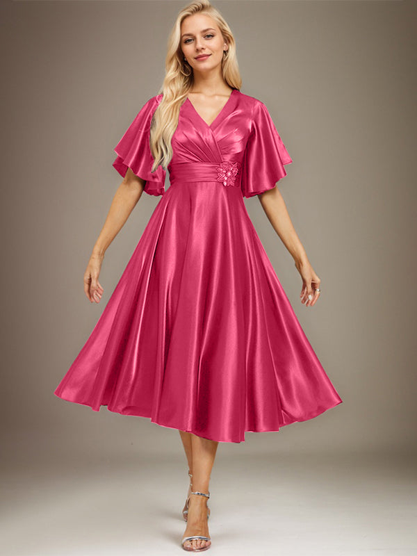 Vestido de novia de satén elástico, corte en A, escote en V, largo hasta la rodilla, con cuentas y pliegues. 